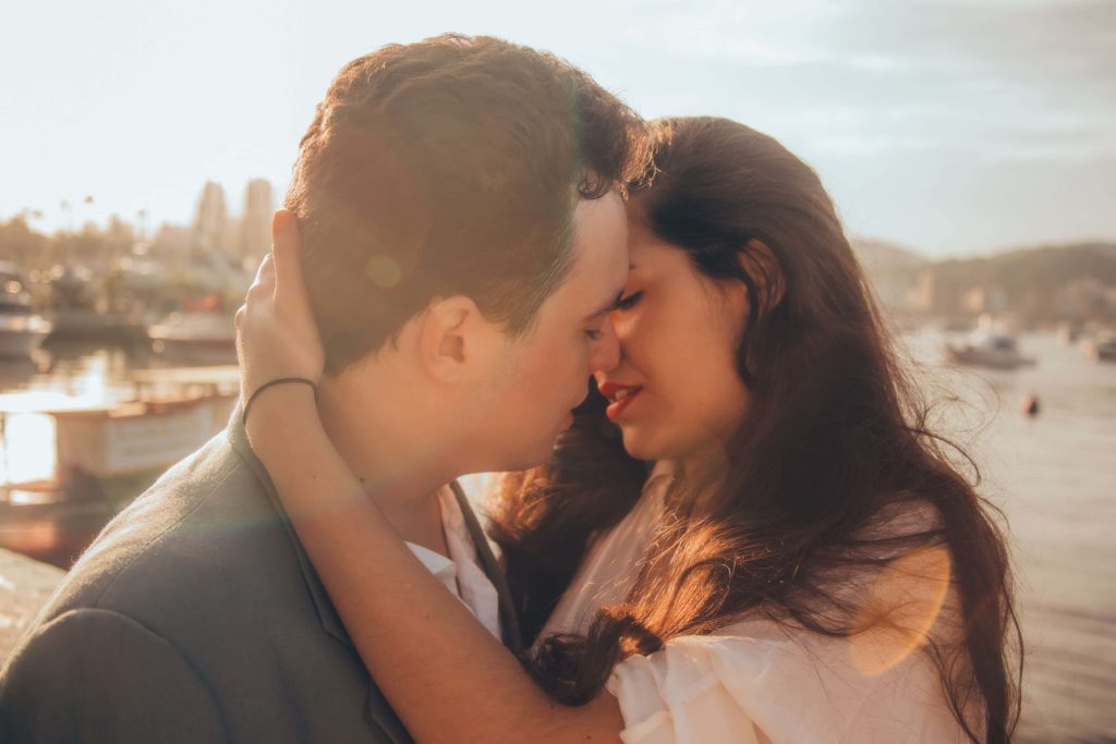 Casal em aproximação de um beijo, simbolizando a paixão.