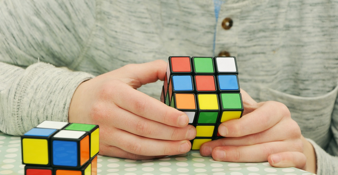 menino com cubo mágico nas mãos, representando desenvolvimento da inteligência fluída