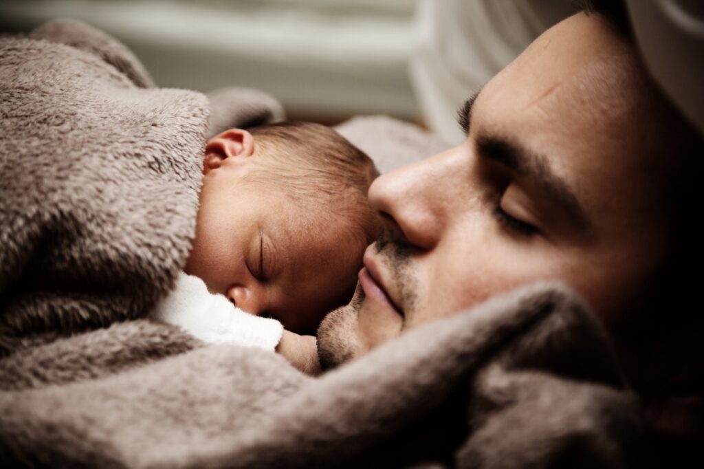 o significado dos sonhos, representado por um bebê dormindo sobre o tórax de seu papai.